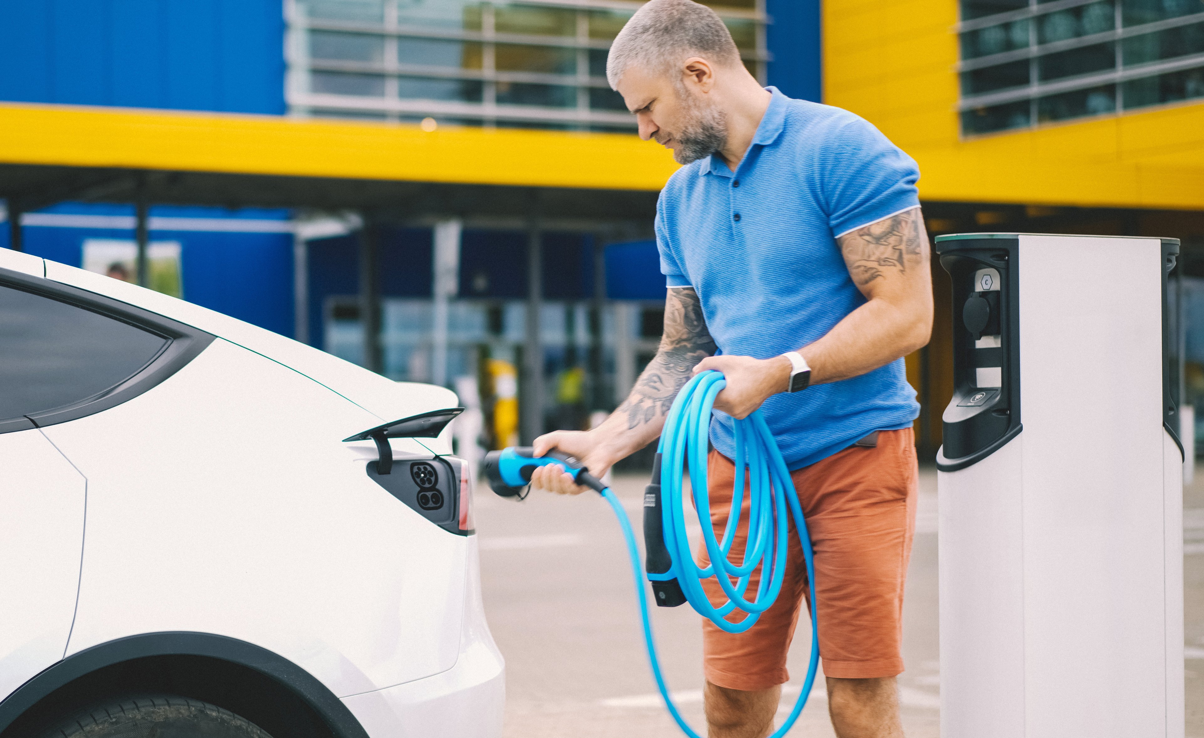 A driver charges an electric vehicle.