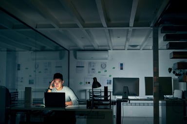 business person sits alone in a dark room