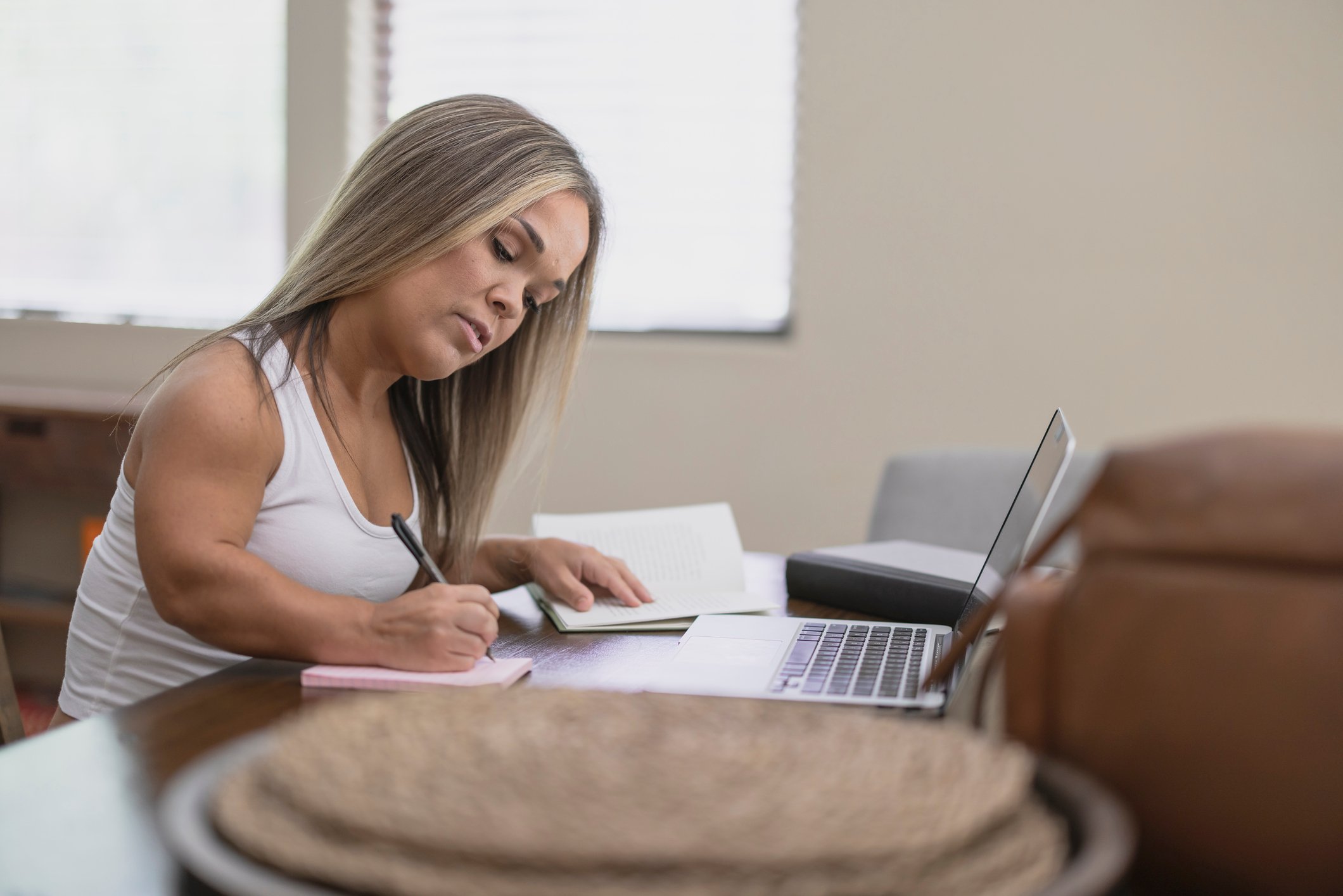 using laptop writing notebook