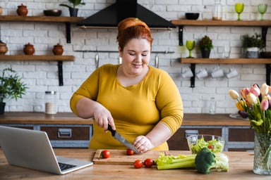 Person cutting a vegetable in a kitchen