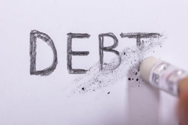Pencil erasing the word debt