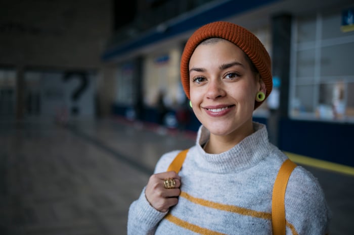 Someone in a knit cap is looking toward the camera and smiling.