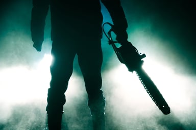 Chainsaw murderer silhouetted in the fog.
