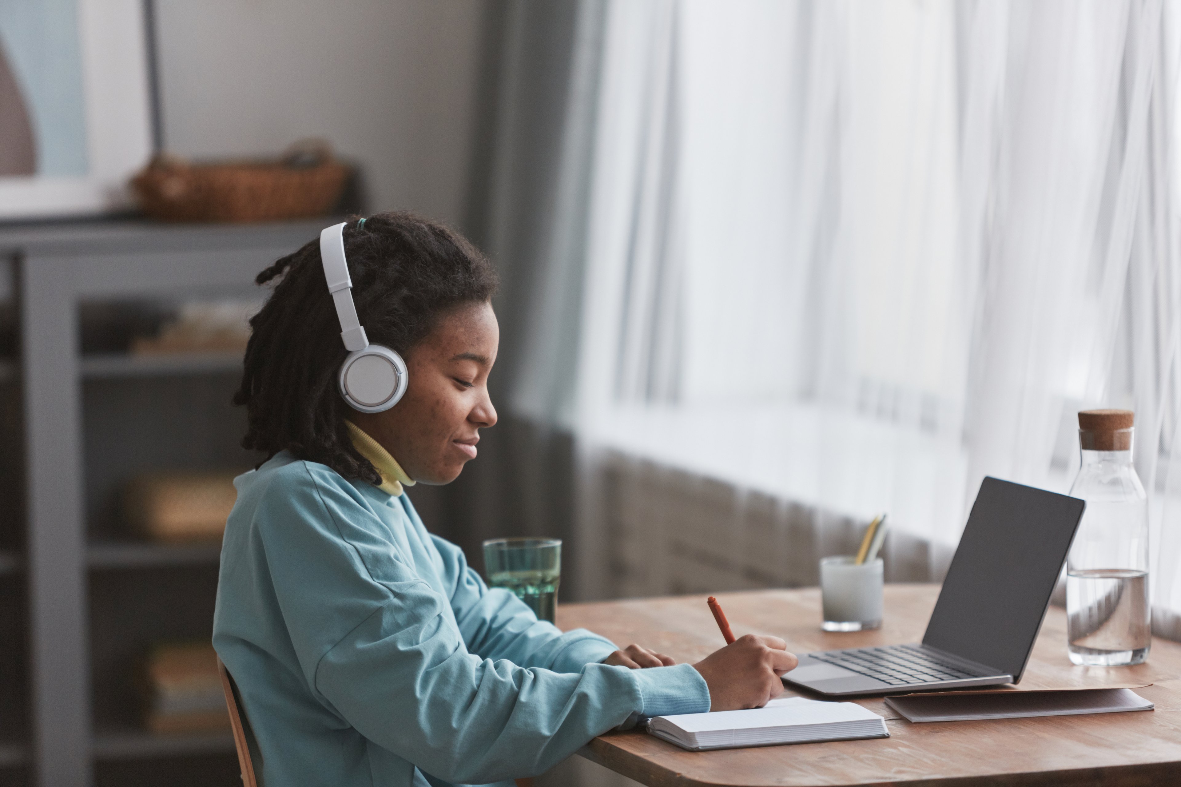 woman researches at a desk wearing headphones