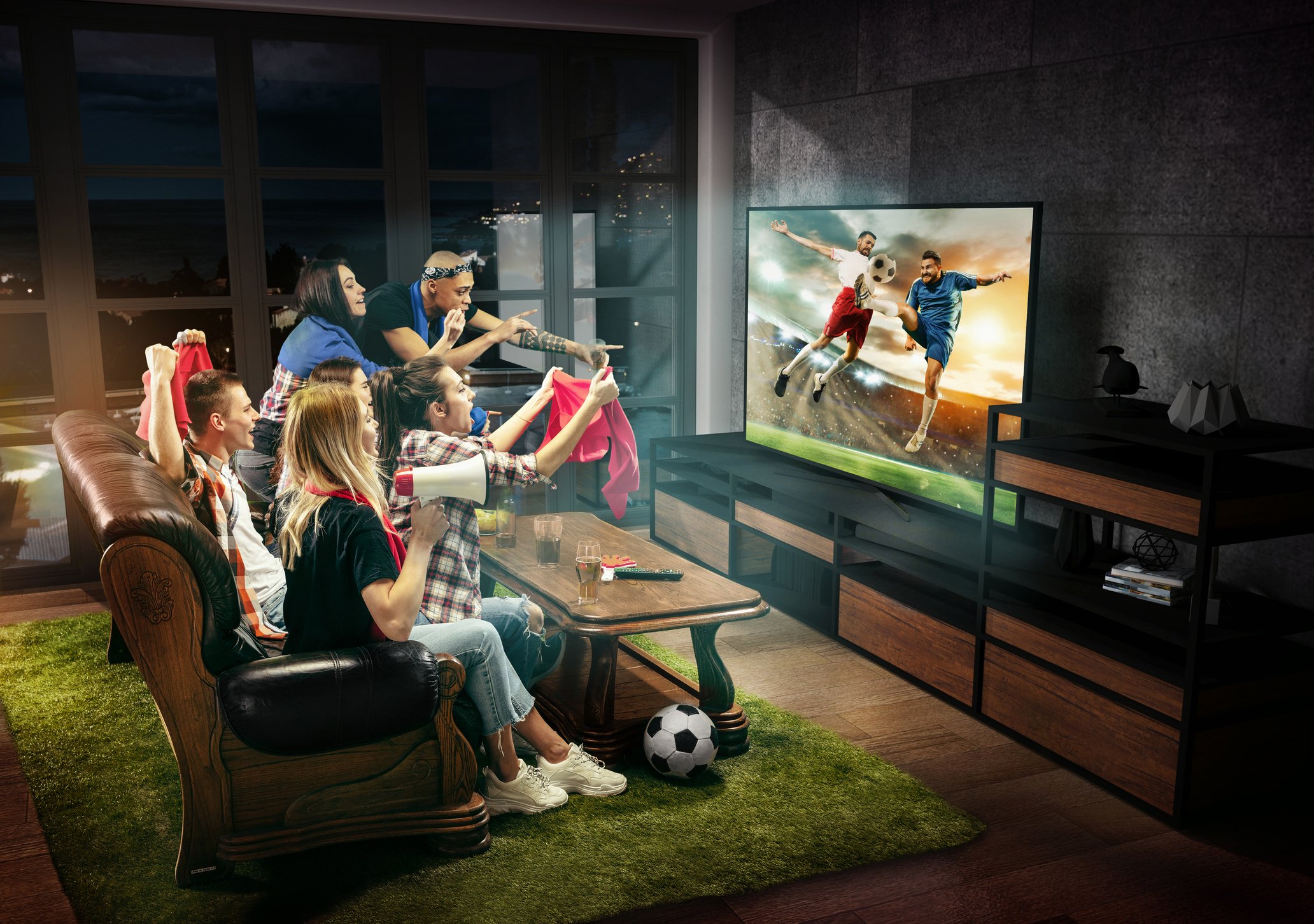 Soccer fans gather around the TV to catch a match.