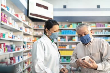 pharmacist helps customer in pharmacy
