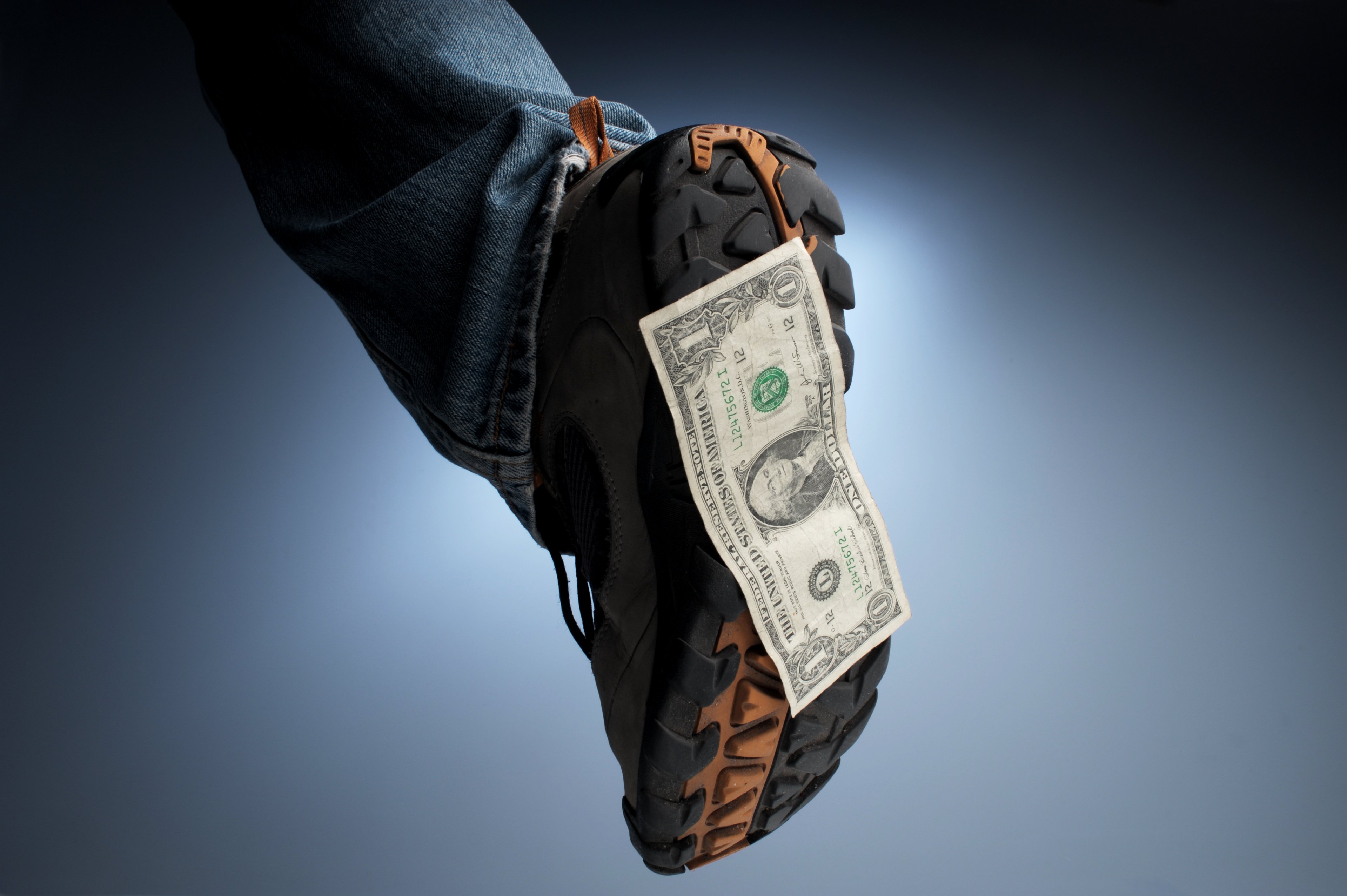 A shoe with a dollar bill on the bottom.