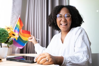 Getty - smiling happy at desk rainbow flag lgbt
