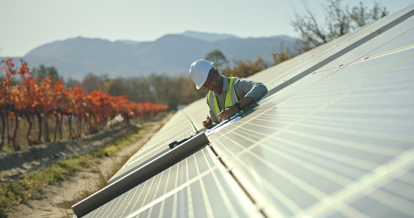 Person inspecting solar panels.