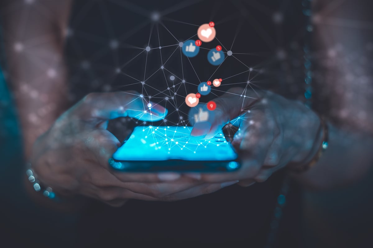 Rendering of a person holding a phone with various apps and connecting lines emitting from the phone.