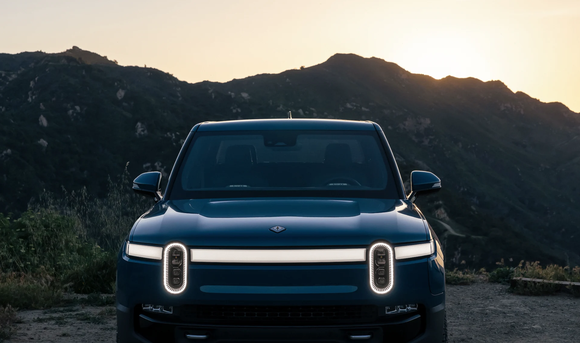 A front view of a Rivian R1 at sunset. 