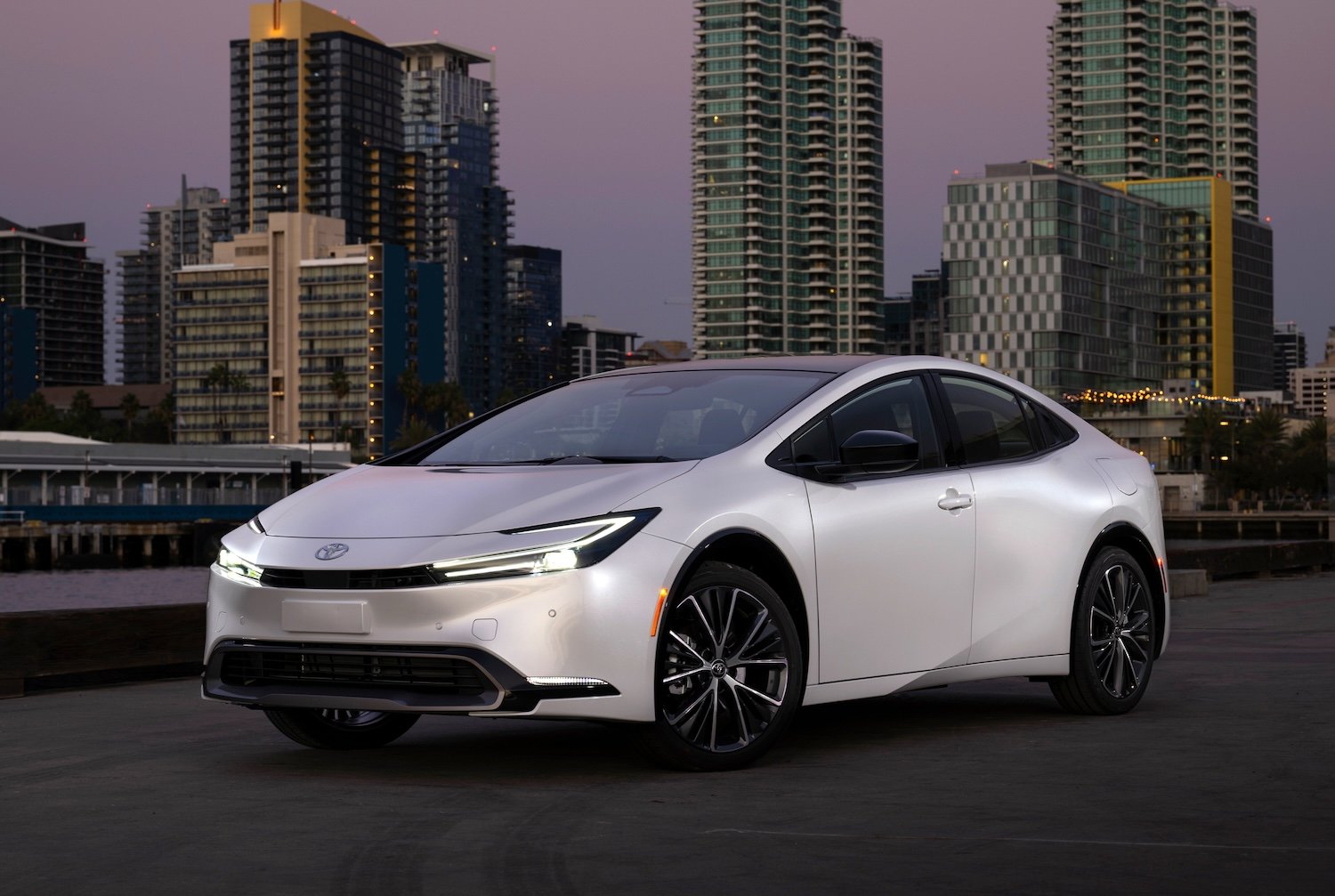 A pearl white 2024 Toyota Prius, a hybrid sedan. 