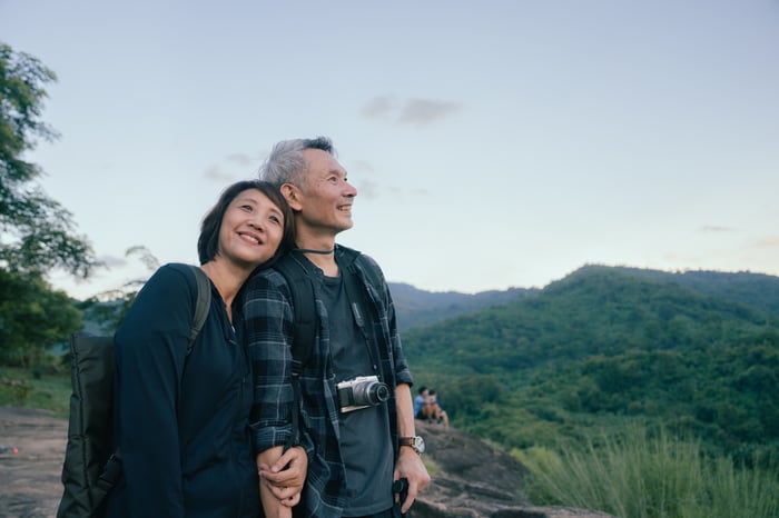 Smiling couple hiking and looking out at nature.