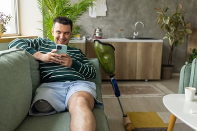 Getty - smiling at phone happy on couch