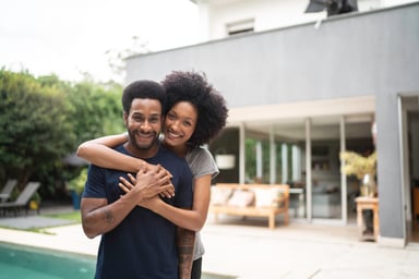 young couple hug celebrate buy home homeowner 