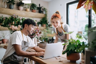 2 people looking at a computer in a plant store