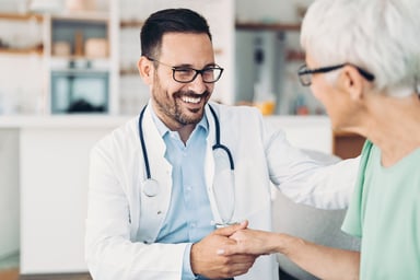 Doctor smiling and holding patient's hand