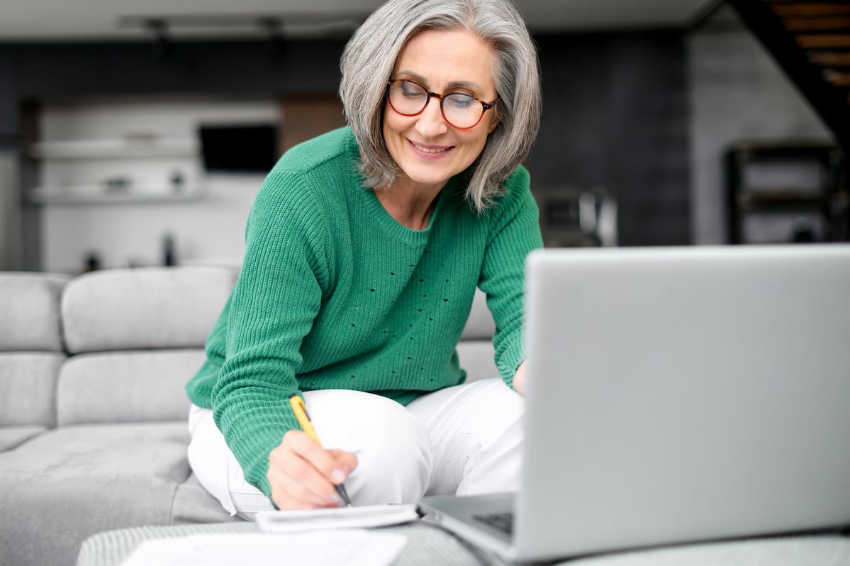 Older adult in living room reviewing finances