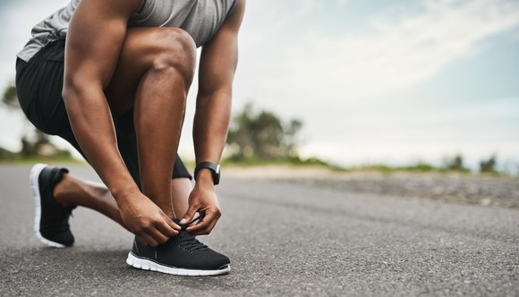 Runner tying a Nike running shoe's laces. 