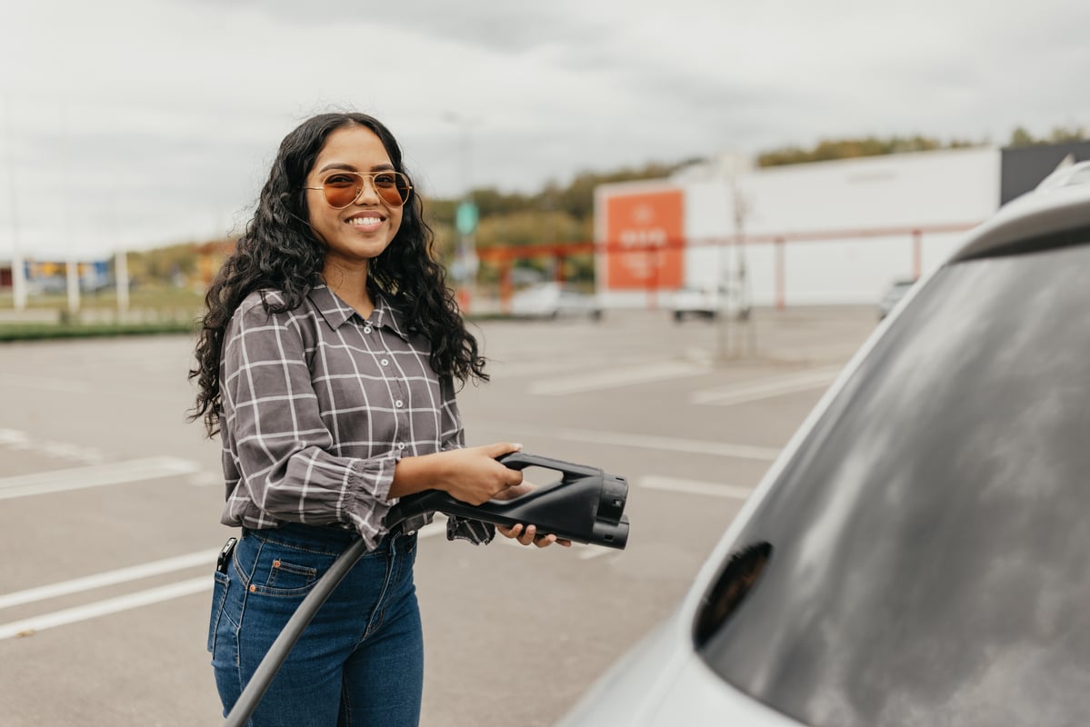 a driver recharges an electric vehicle.