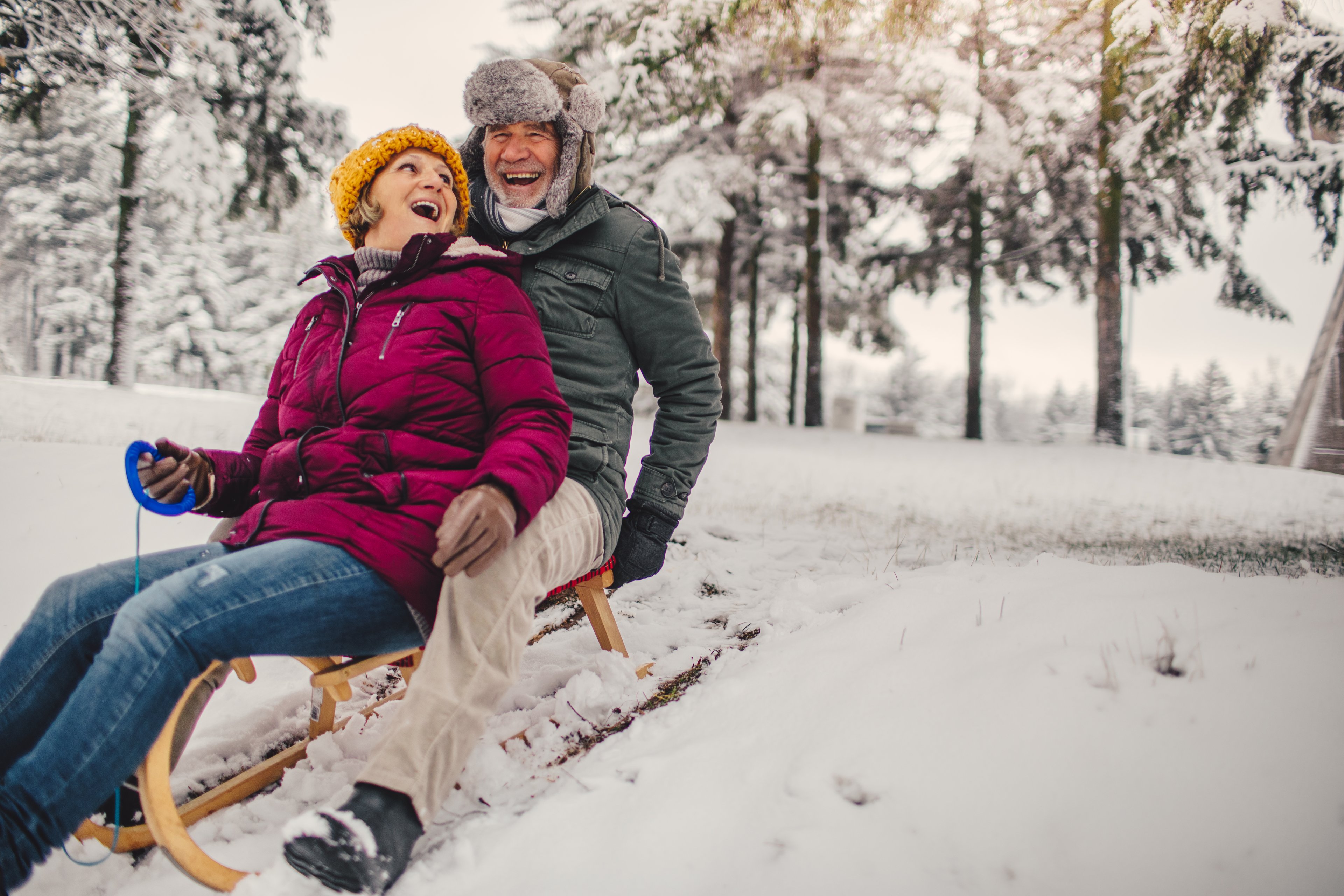 Two people riding on a snow sled down a hill.