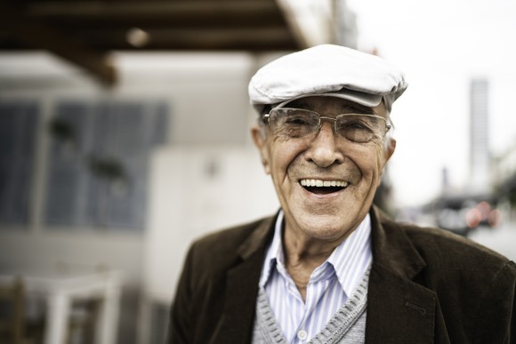 A smiling person wearing a hat.