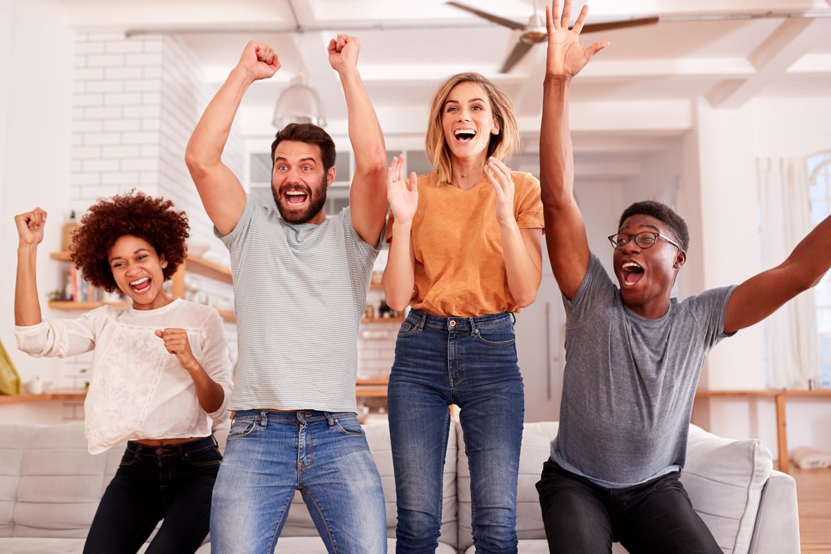 people jump off a couch in celebration.