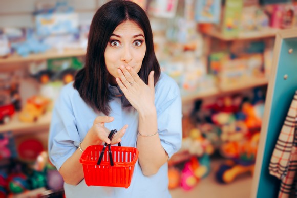 A person holds a tiny shopping basket.