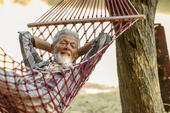 Smiling person relaxing in a hammock.