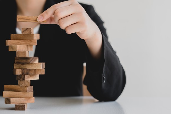 A person stacks blocks on a table.