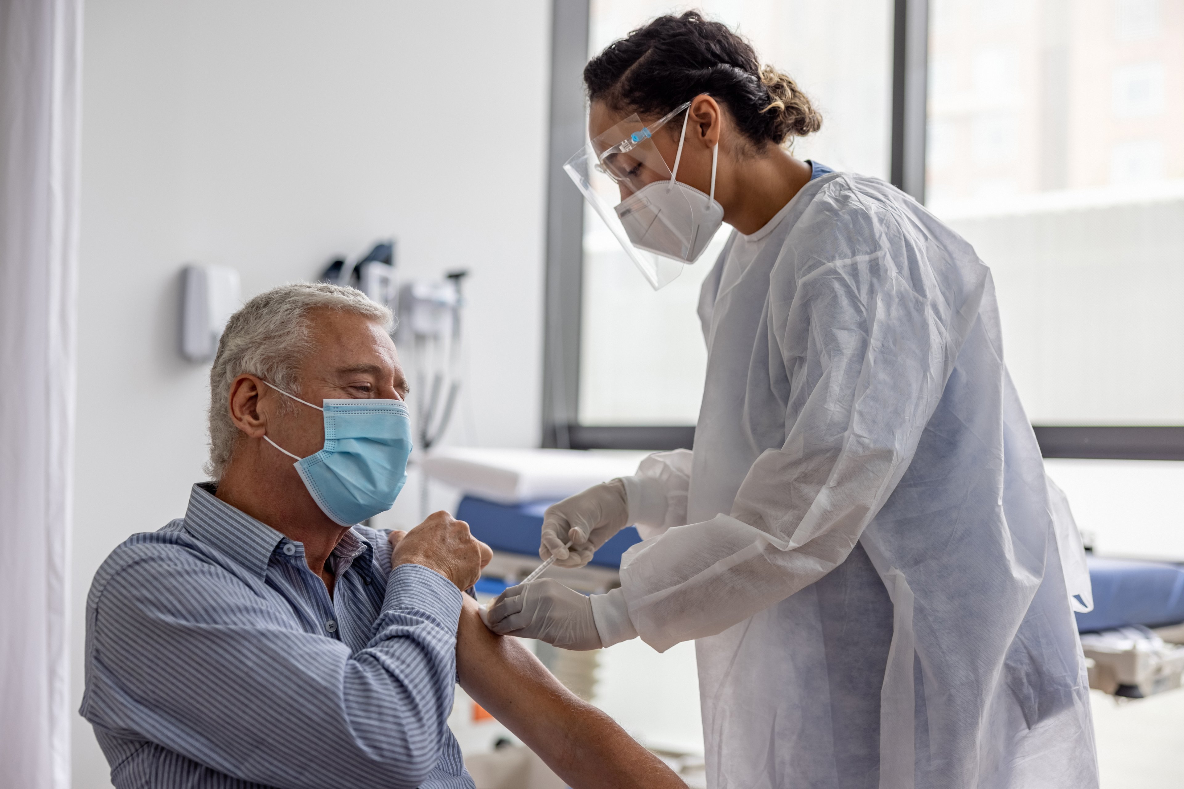 Person getting vaccine from medical professional. 