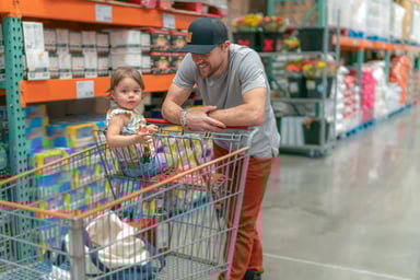 Person shopping with their child in a warehouse.