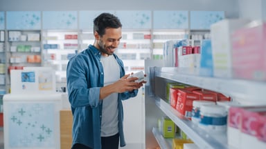 Person shopping for cough medicine in a pharmacy.