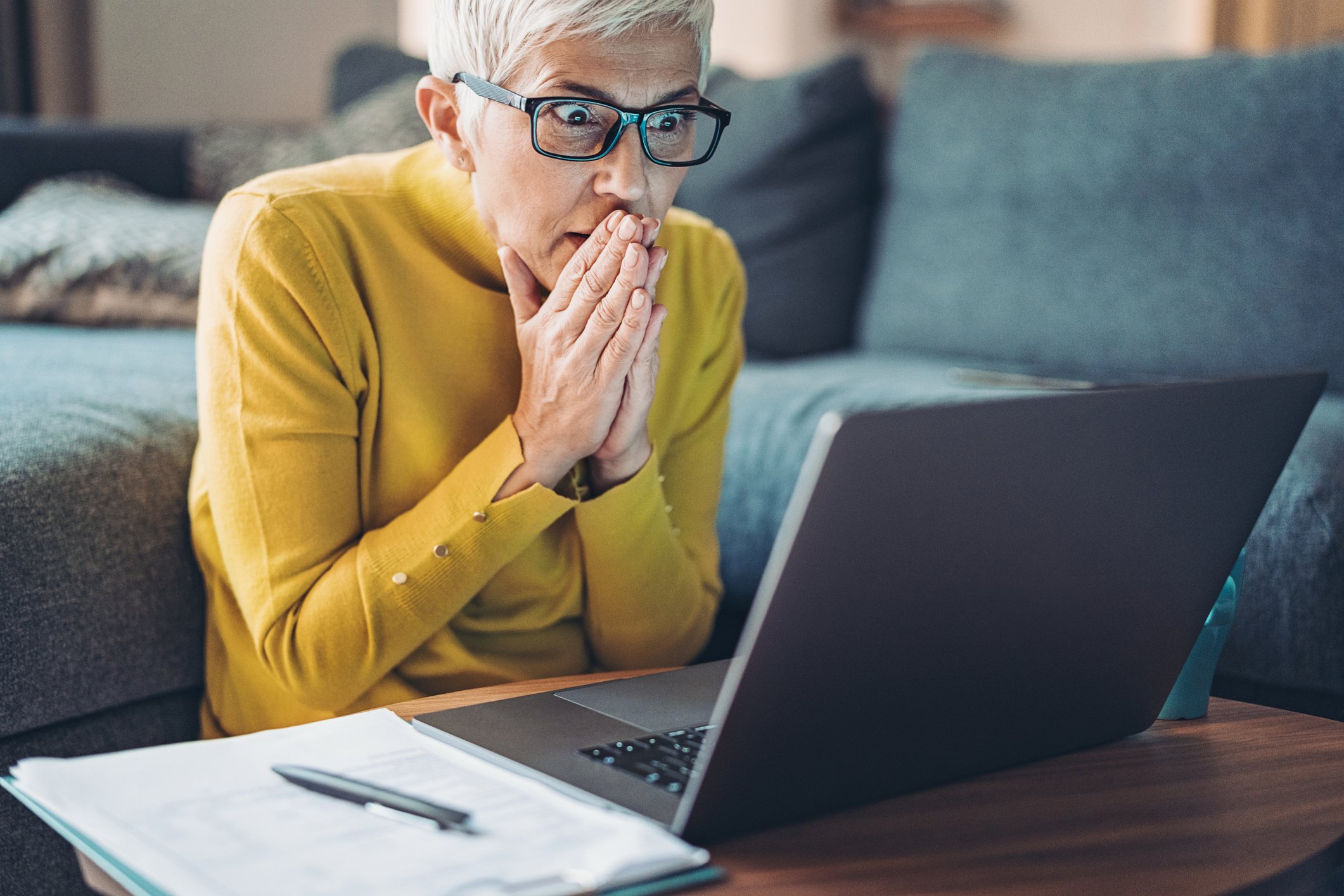 Mature woman looking at computer in shock