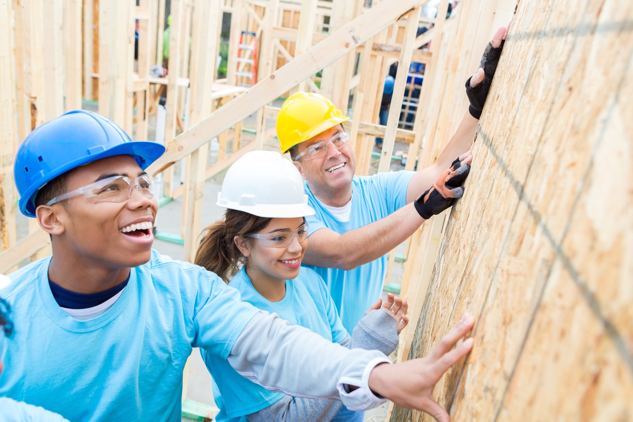 Three people working on a building construction