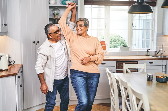 Two people dancing in a kitchen.