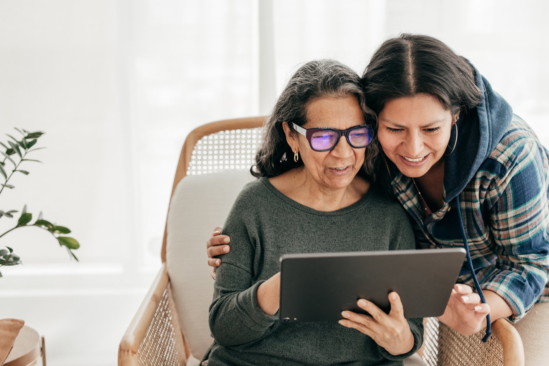 Two people looking at a tablet and smiling.