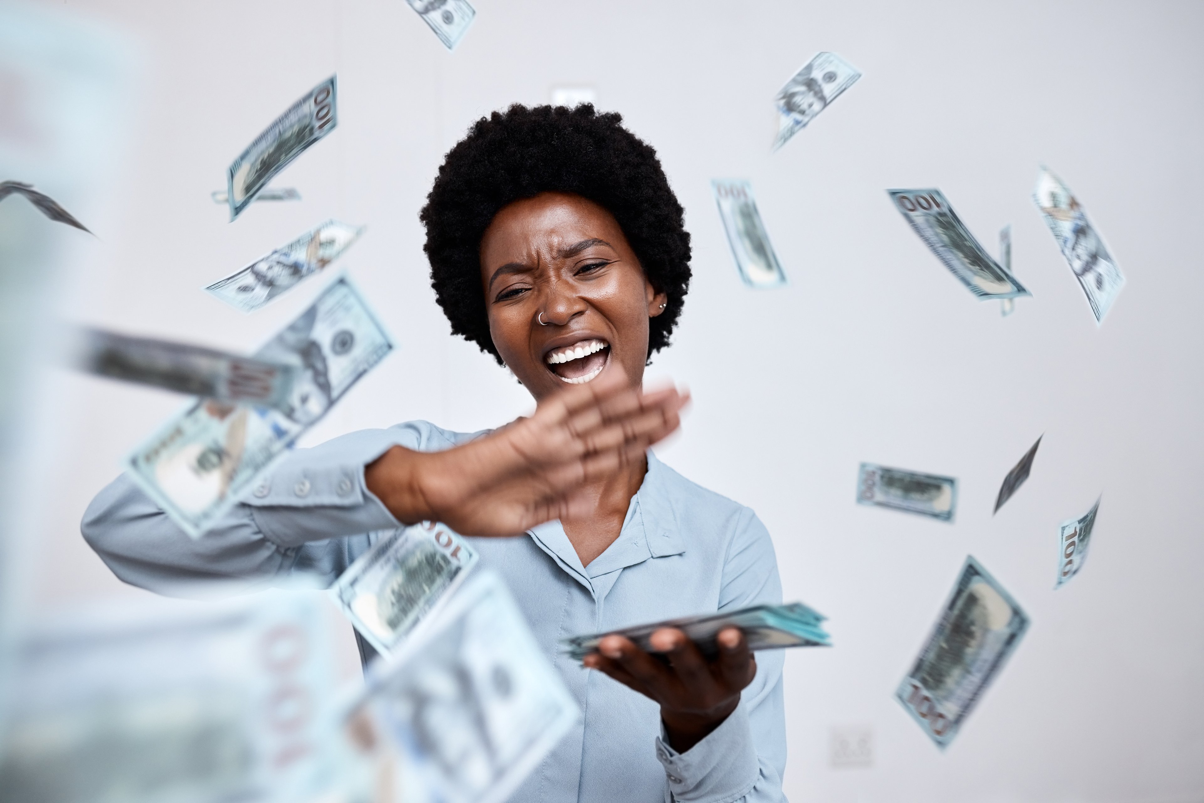 A happy person throwing handfuls of cash.