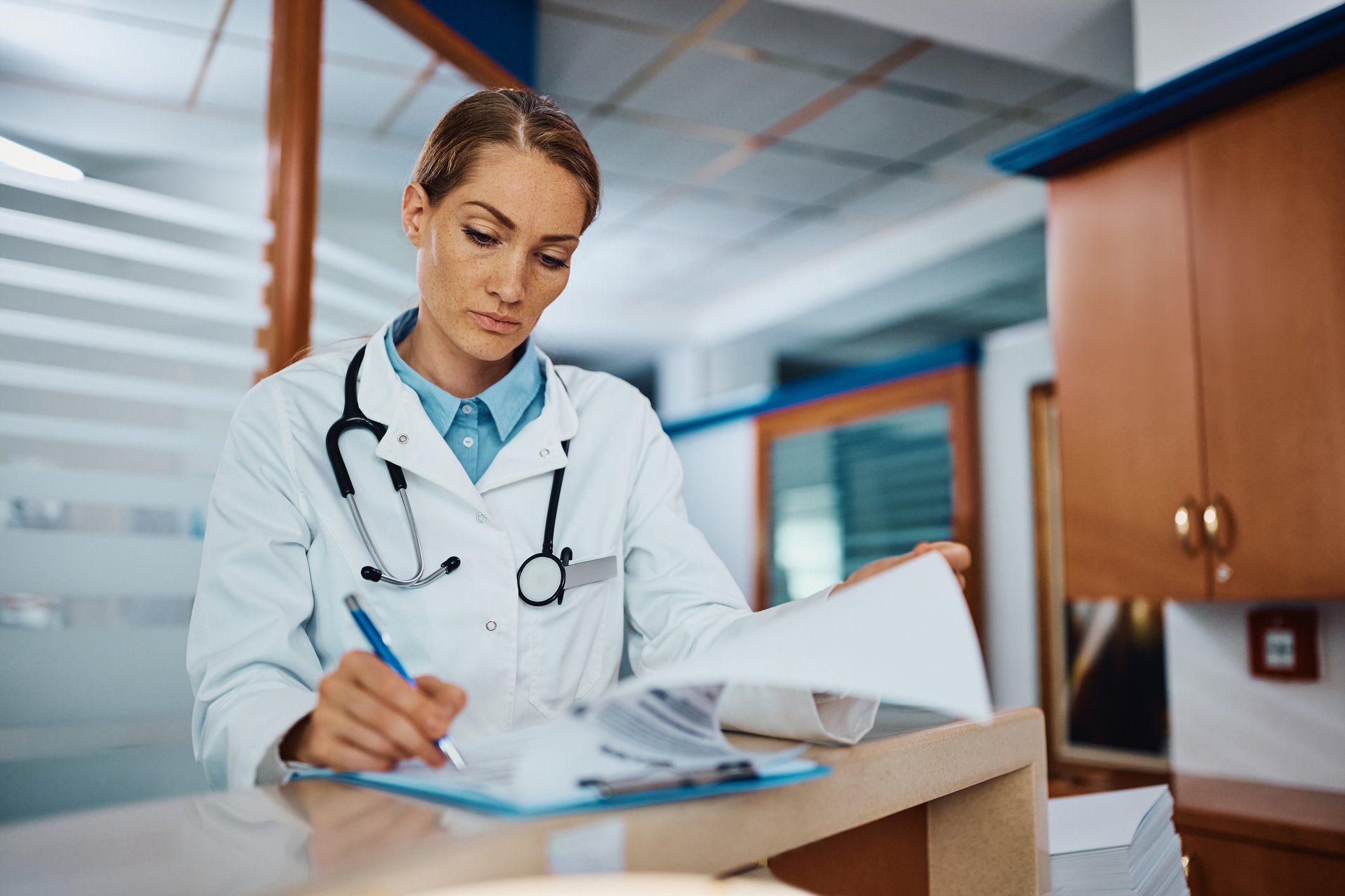 doctor writing medical reports at desk