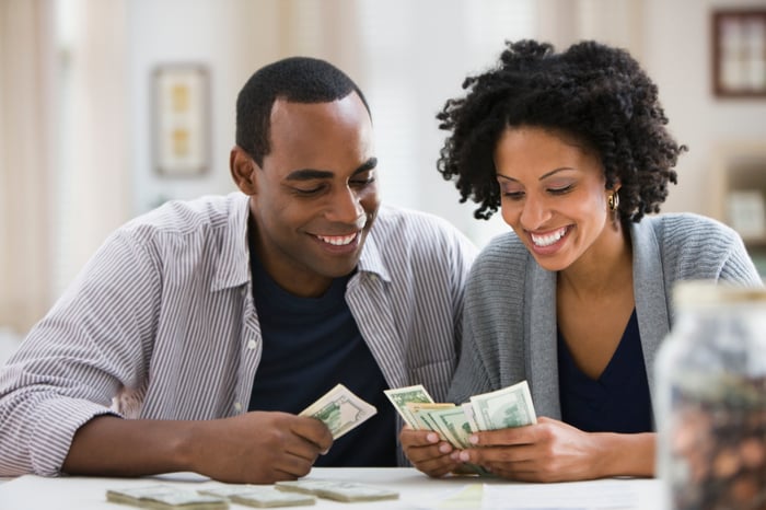 Smiling couple counting money.