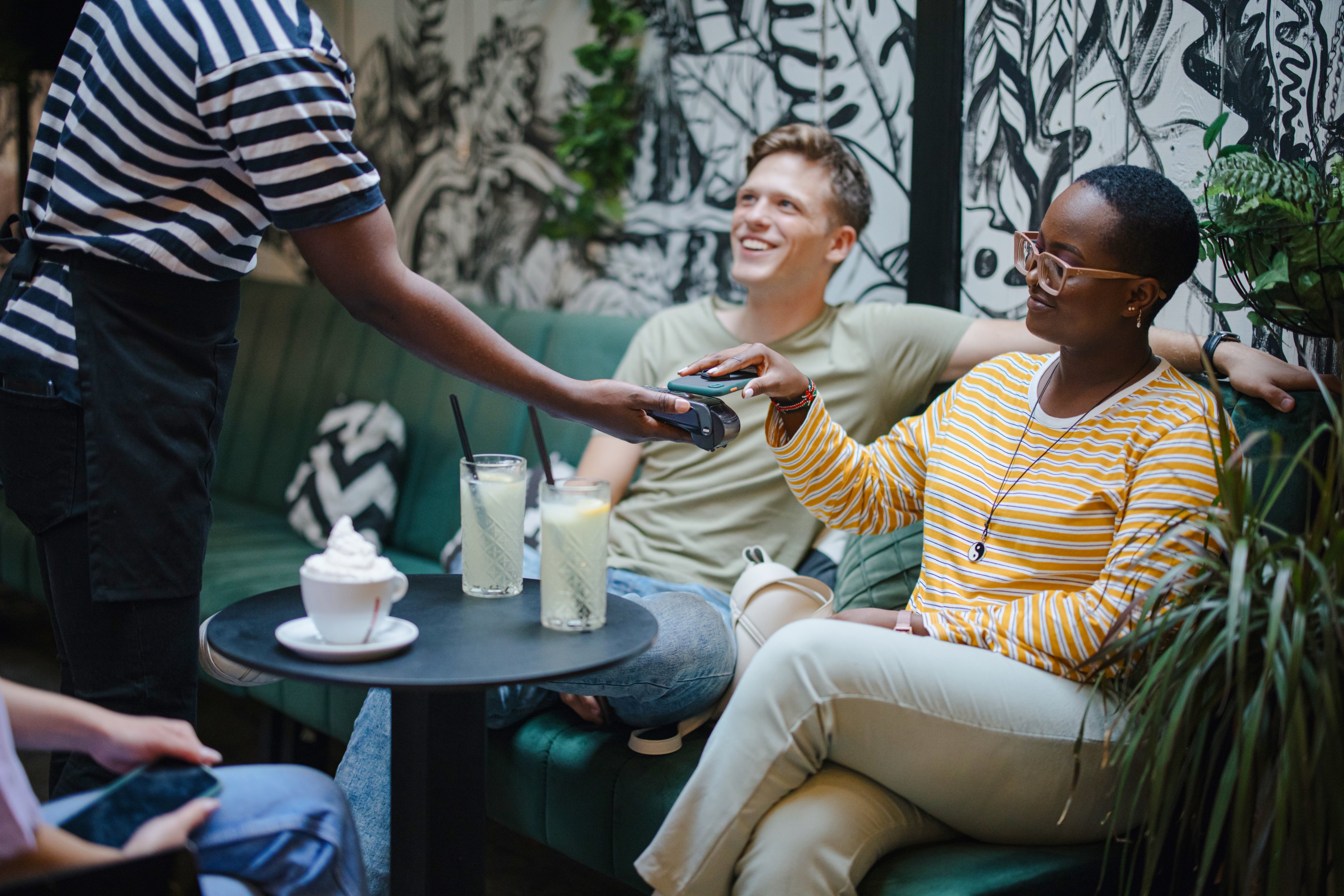 Person making a payment with a smartphone in a restaurant.