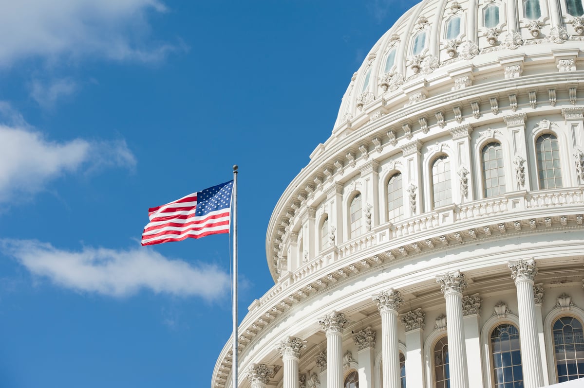 The Capitol dome with a flag next to it