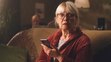 Person holding a phone with a scary expression.