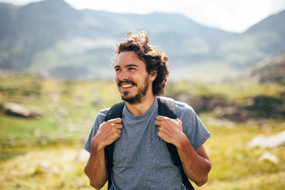 Smiling person hiking in mountains.