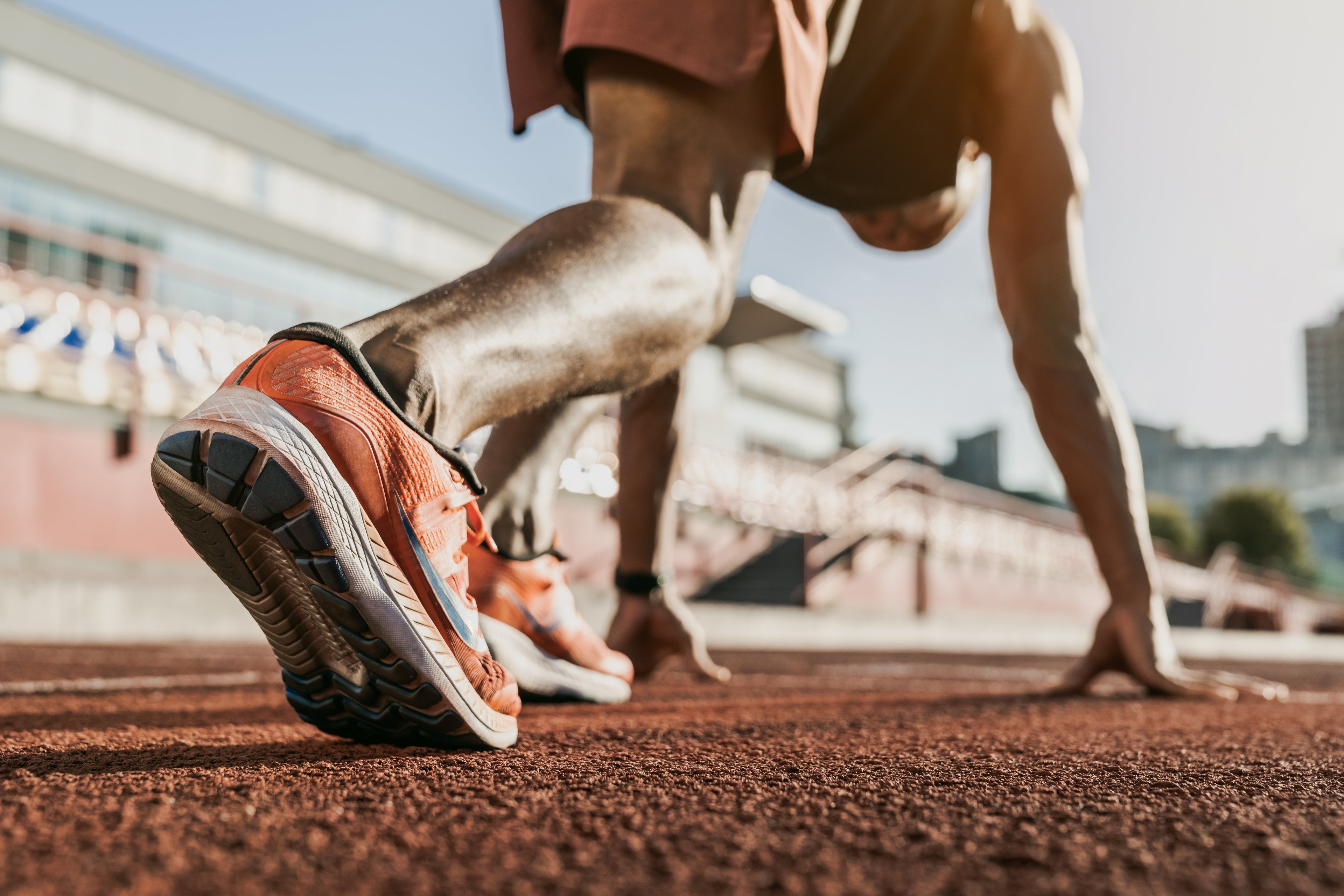 Runner in starting blocks, with focus on their shoes.