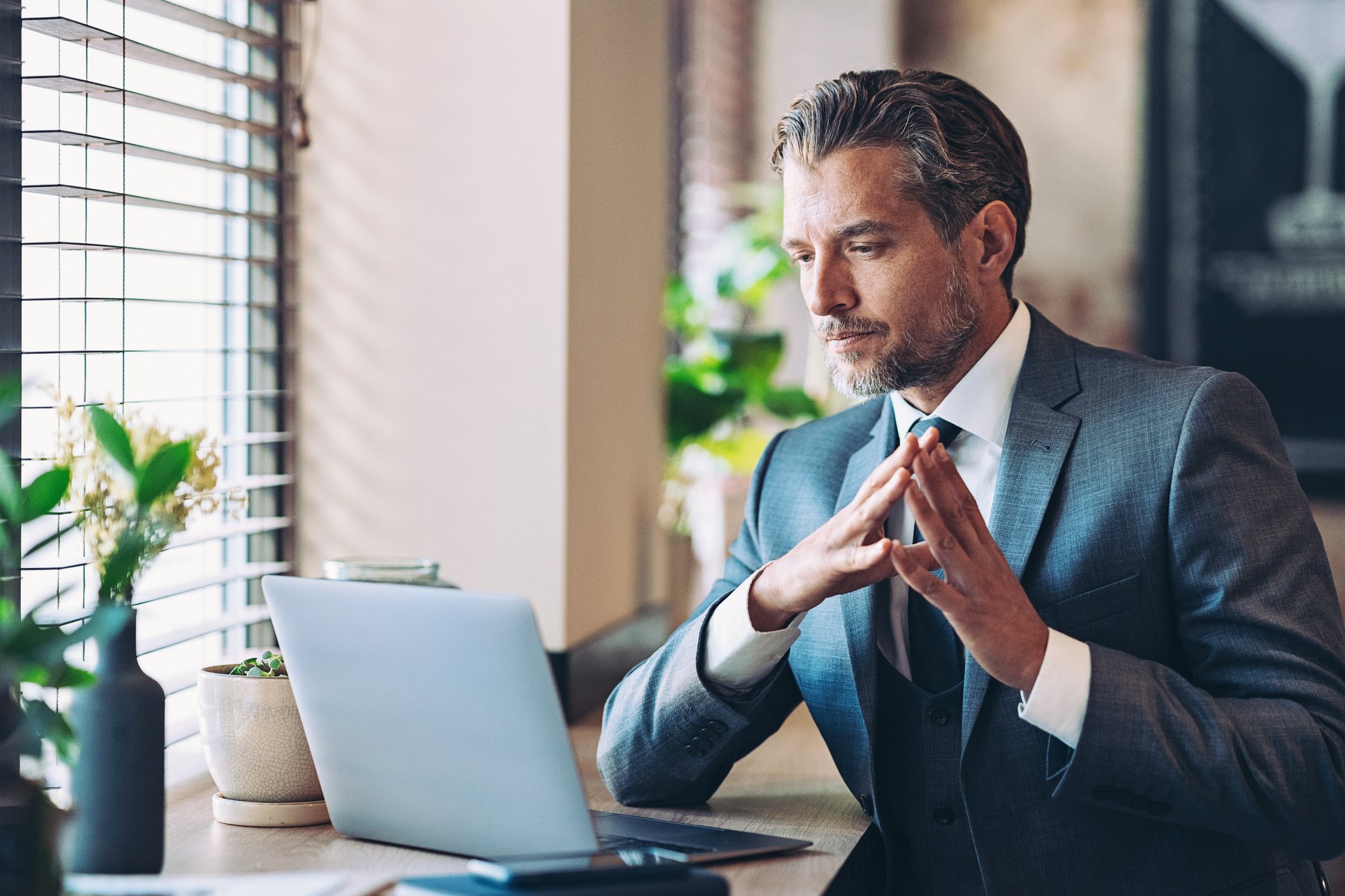 A pensive investor sits before a computer.