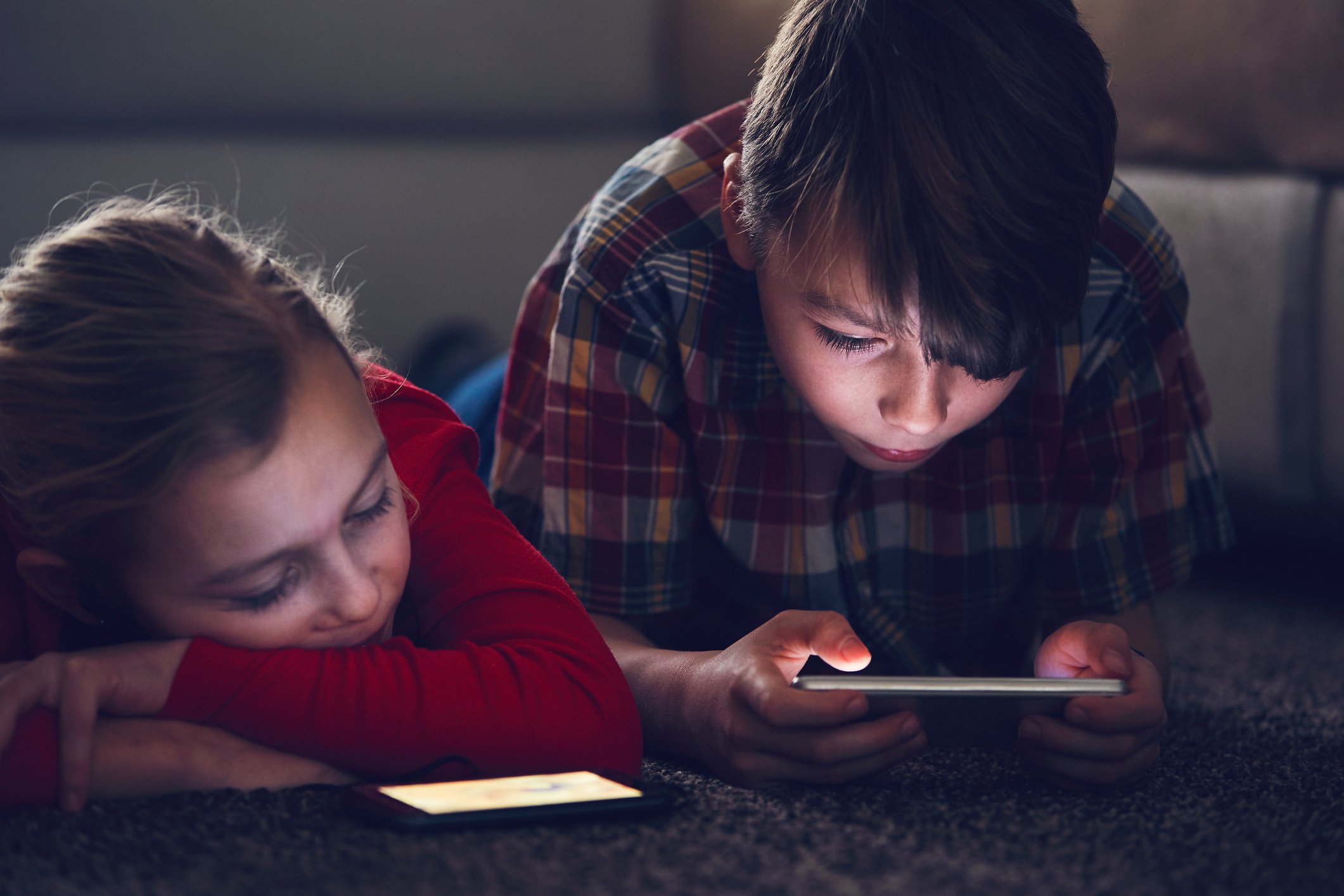 two children play games on mobile phone