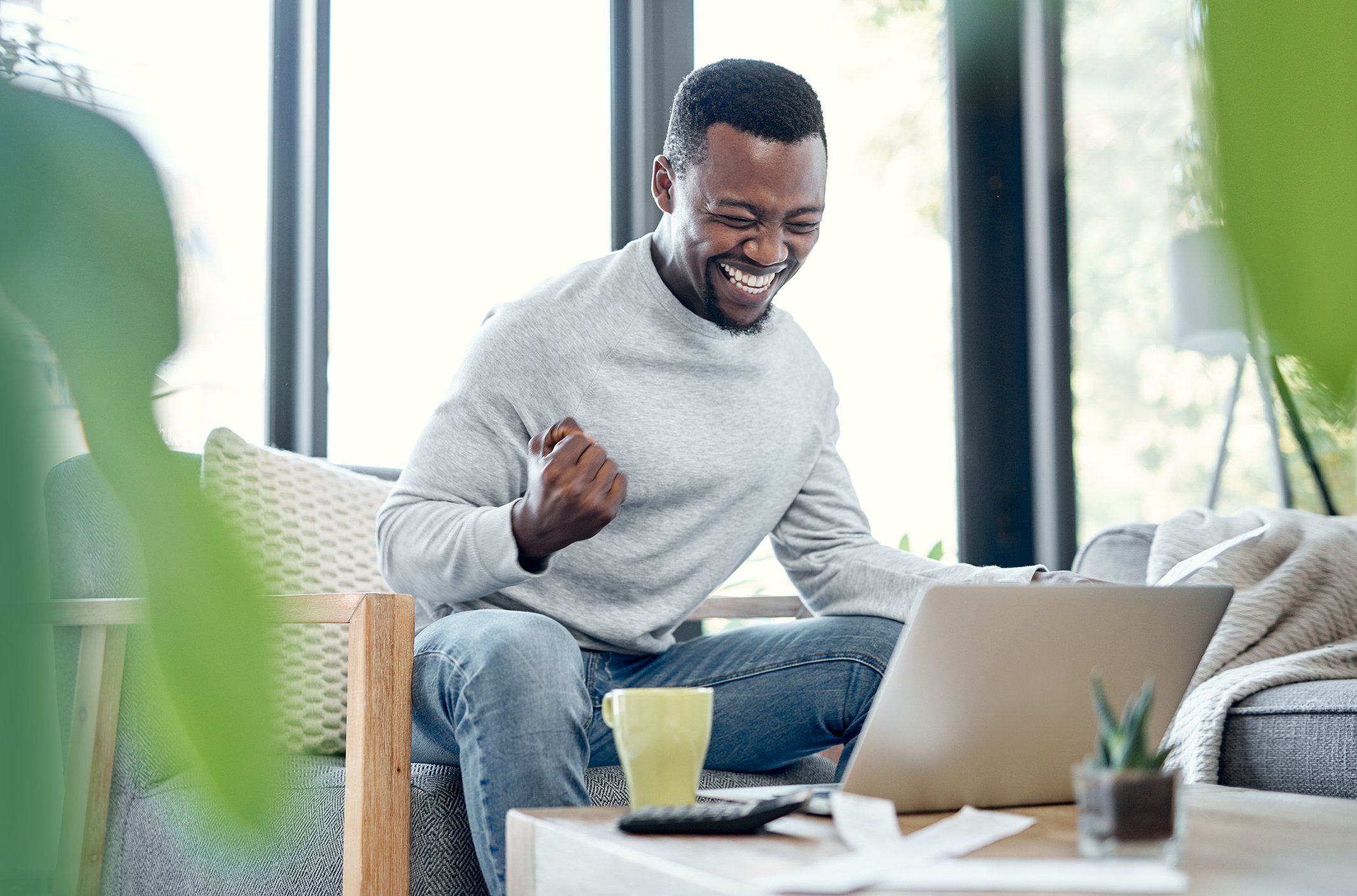 Person celebrating success on laptop 
