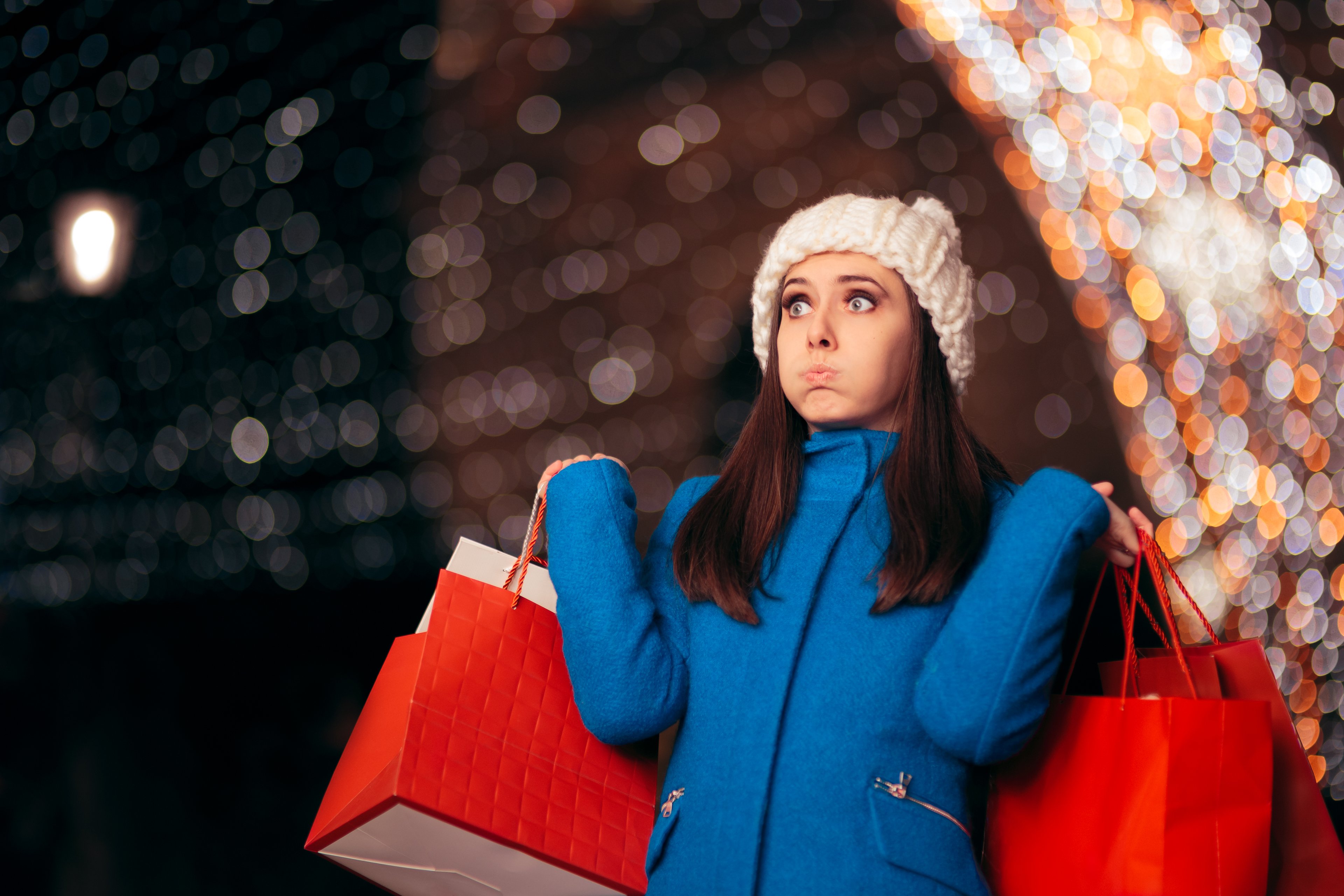 A shopper holding two red bags.