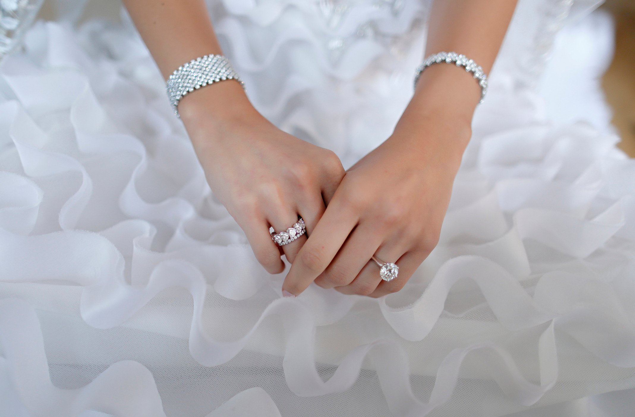 A bride's hands with jewelry on them.
